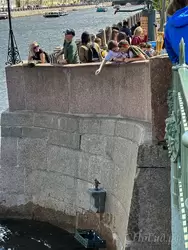 Туристы кидают монетки на памятник Чижик-Пыжик